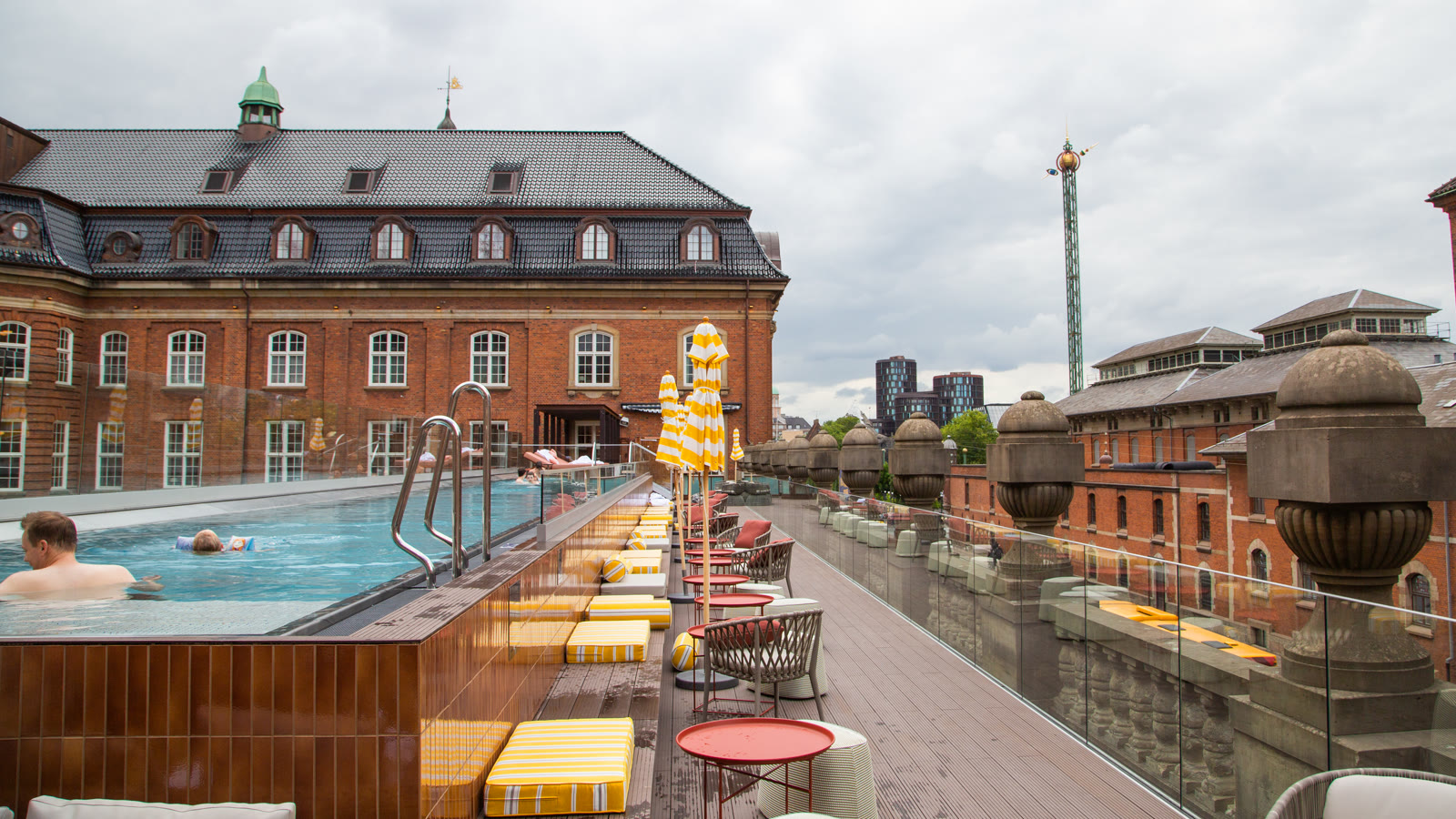 Villa Copenhagens 25 meter lange tagpool med liggestole og Tivolis Himmelskibet i baggrunden